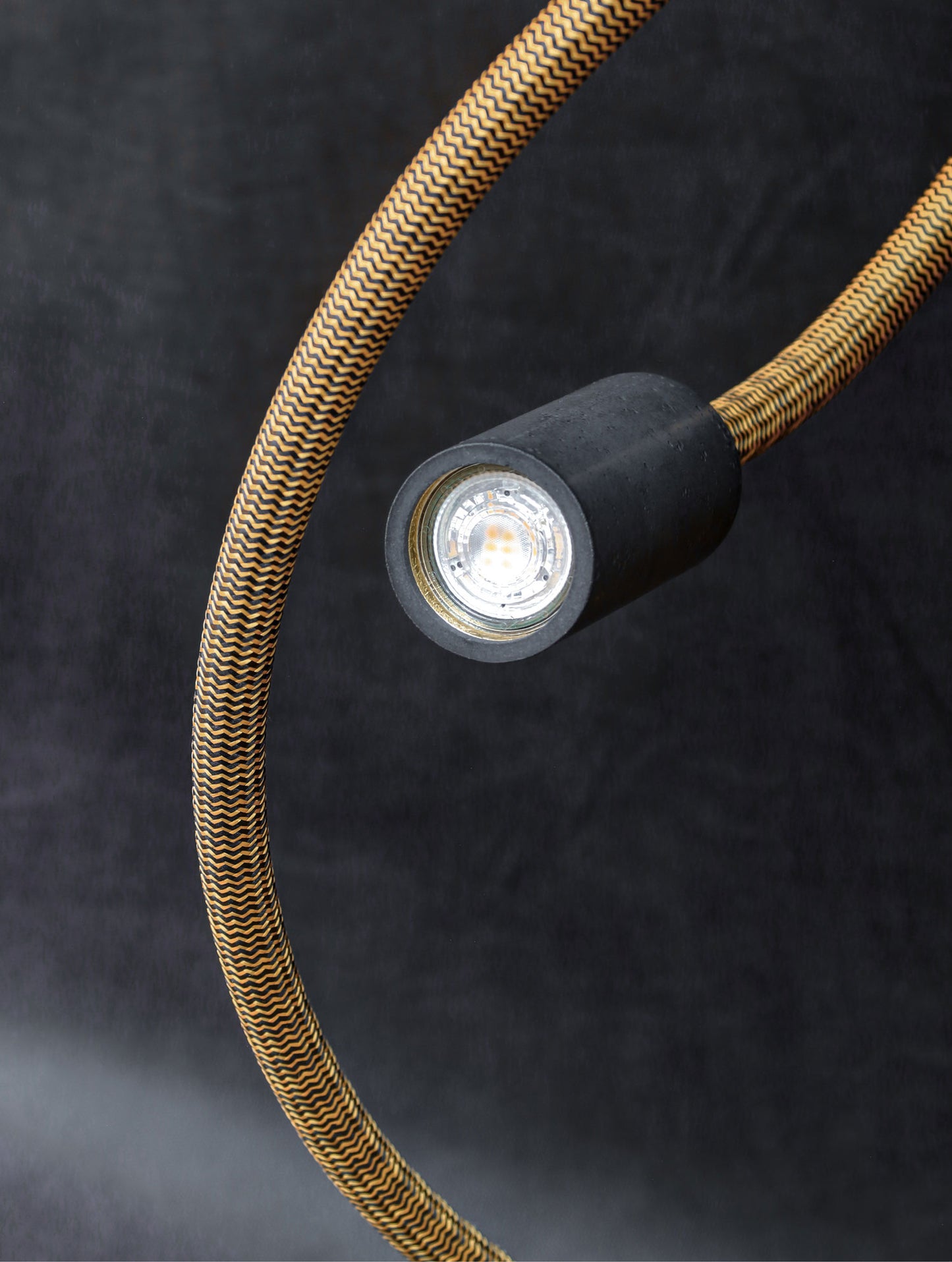 Detailaufnahme vom Lampenschirm aus Beton vor schwarzem Hintergrund von der Lampe 'NAGA'